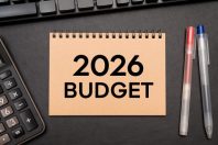 2026 BUDGET text on Notebook with calculator and office supplies. Budget planning concept.