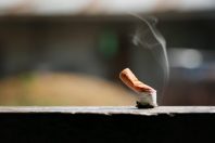 Brown color filter bottom cigarette on wooden floor.