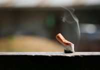 Brown color filter bottom cigarette on wooden floor.
