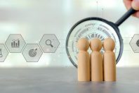 Hand use magnifying glass search wooden person stands with HR human resources icons for personal leader training skill or leadership and challenge business team.