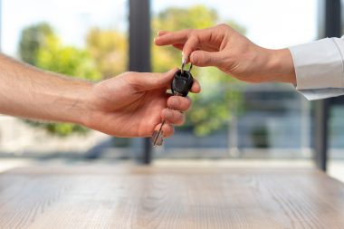 Man taking key from young lady in formal wear shirt