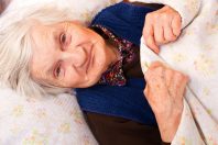 Elderly lonely woman in the bed