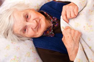 Elderly lonely woman in the bed