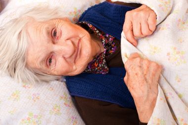Elderly lonely woman in the bed