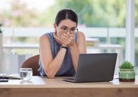 Surprise, mistake or error with a business woman looking shocked while working on a laptop in her office. Computer, glitch and problem with a scared female employee worried about a system failure