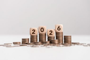 Stacks of coins with wooden blocks forming number 2026 for target financial growth, investment planning for money savings to wealth, business goals concept. Budget and tax, Happy new year 2026
