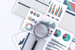 ビジネスデータをプリントした書類と虫メガネ