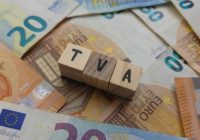 TVA acronym made of wooden letter cubes on pile of Euro banknotes. Taxe sur la Valeur Ajoutée (Value Added Tax)