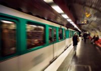 Blurry motion image of woman walking in a subway station. Train approaches. Lifestyle and culture concept