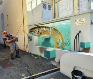 Une truite en trompe-l’œil mord à l’hameçon dans un passage du bourg, lors de l’édition du Khrôma Festival, placé, en 2024, sous le thème de l’inattendu.
